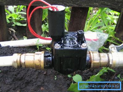 Gru elettrica sulla strada nel paese per automatizzare l'irrigazione del giardino Gru elettrica sulla strada nel paese per automatizzare l'irrigazione del giardino