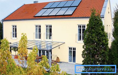 Foto della casa, sul tetto di cui sono installati i collettori solari Foto della casa, sul tetto di cui sono installati i collettori solari
