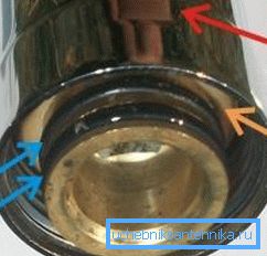 La freccia rossa indica il dado di serraggio, la freccia arancione indica il sigillo di chiusura in plastica e quella blu indica due rondelle di tenuta. La freccia rossa indica il dado di serraggio, la freccia arancione indica il sigillo di chiusura in plastica e quella blu indica due rondelle di tenuta.