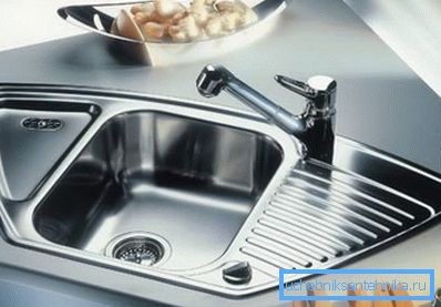 Un set da cucina con un lavabo angolare in acciaio inossidabile sembra molto elegante, soprattutto se ci sono altri elementi lucidi nel design.