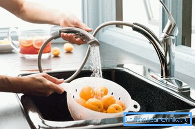 Lavare frutta sotto un beccuccio flessibile Lavare frutta sotto un beccuccio flessibile