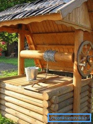 Nella foto - un pozzo con un portello sotto una tettoia Nella foto - un pozzo con un portello sotto una tettoia