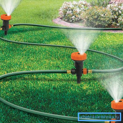 La foto mostra un ugello dell'irrigatore, collegato con un tubo da giardino. La foto mostra un ugello dell'irrigatore, collegato con un tubo da giardino.