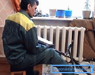 Nella foto, l'idraulico sta lavando i radiatori nell'appartamento Nella foto, l'idraulico sta lavando i radiatori nell'appartamento