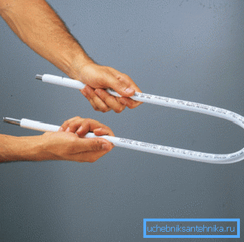 Nella foto - la piegatura del tubo di metallo-plastica utilizzando una molla Nella foto - la piegatura del tubo di metallo-plastica utilizzando una molla