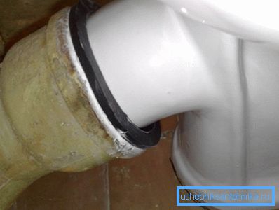 Collegamento della toilette alle fognature in ghisa con un bracciale di gomma Collegamento della toilette alle fognature in ghisa con un bracciale di gomma