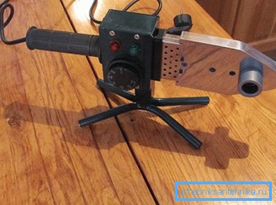 Saldatore di tubi di plastica sulla tavola di legno Saldatore di tubi di plastica sulla tavola di legno