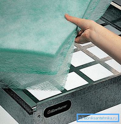 Posa di materiale a maglia fine e fibrosa nell'alloggiamento del filtro Posa di materiale a maglia fine e fibrosa nell'alloggiamento del filtro