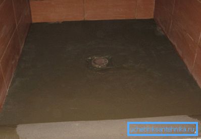 Il massetto di cemento viene versato nella base del pavimento dopo l'installazione di uno scarico.