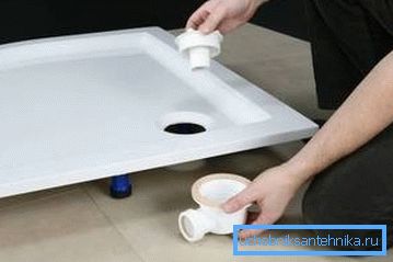 Sostituendo il sifone nella doccia con le mani su una padella bassa Sostituendo il sifone nella doccia con le mani su una padella bassa